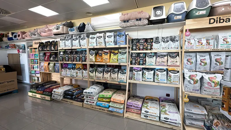 Pasillo de la tienda con estanterías llenas de pienso y accesorios